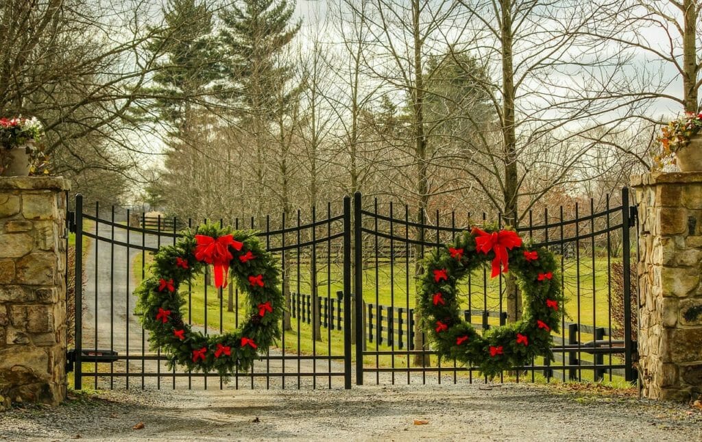 A gated driveway with Christmas wreaths